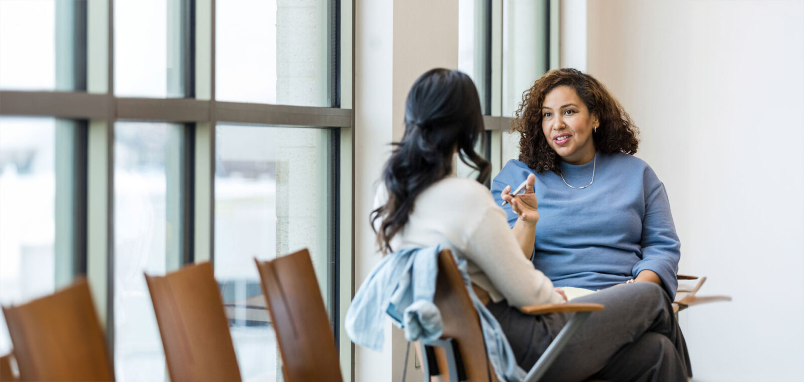 An unrecognizable patient listens as her mature adult female therapist gives her some straightforward advice.